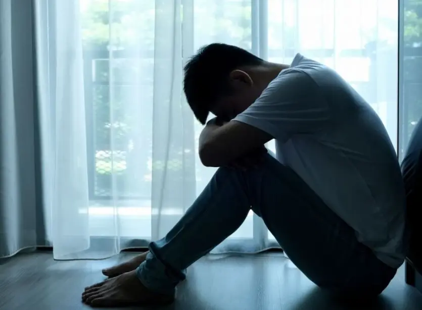 身体を抱える男