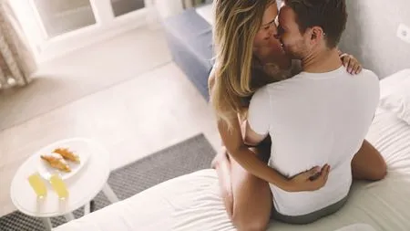 ベッドで正面から抱き合う外国人男女