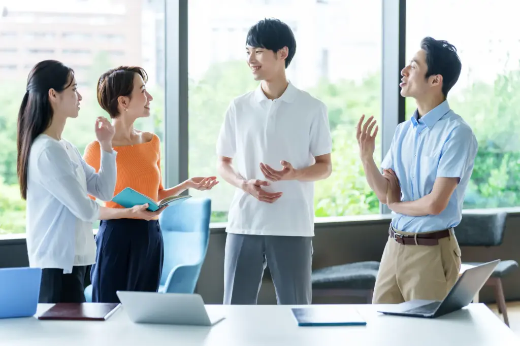 仕事の会話をしている男女4人